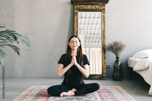 Beautiful brunette fitness woman meditate, doing yoga indoors at home. Staying fit and healthy photo