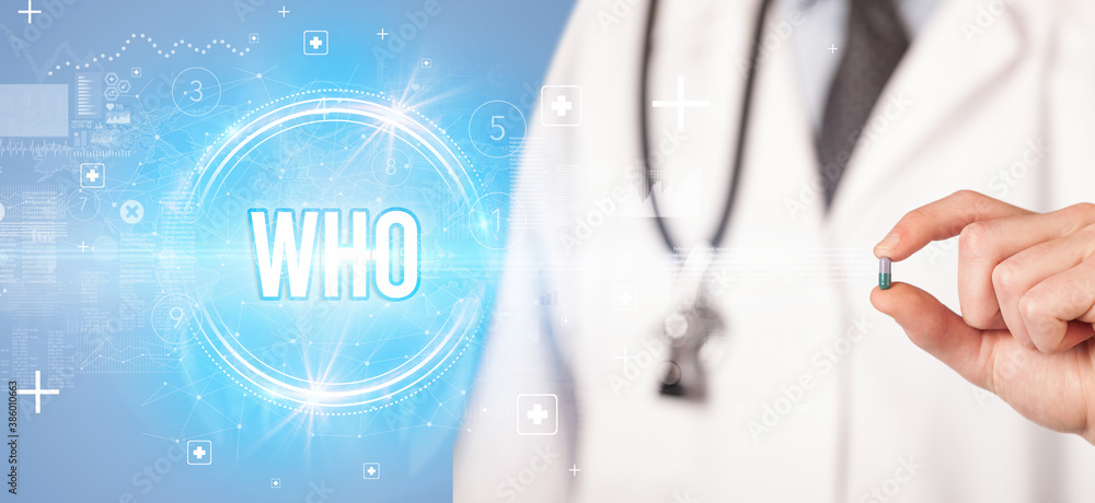 Close-up of a doctor giving you a pill with WHO abbreviation, virology concept Close-up of a doctor giving you a pill with WHO abbreviation, virology concept