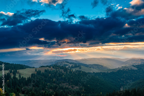 Sunset over the autumn forests in the Carpathian mountains, last sunrays painting the horizon. © Alpar