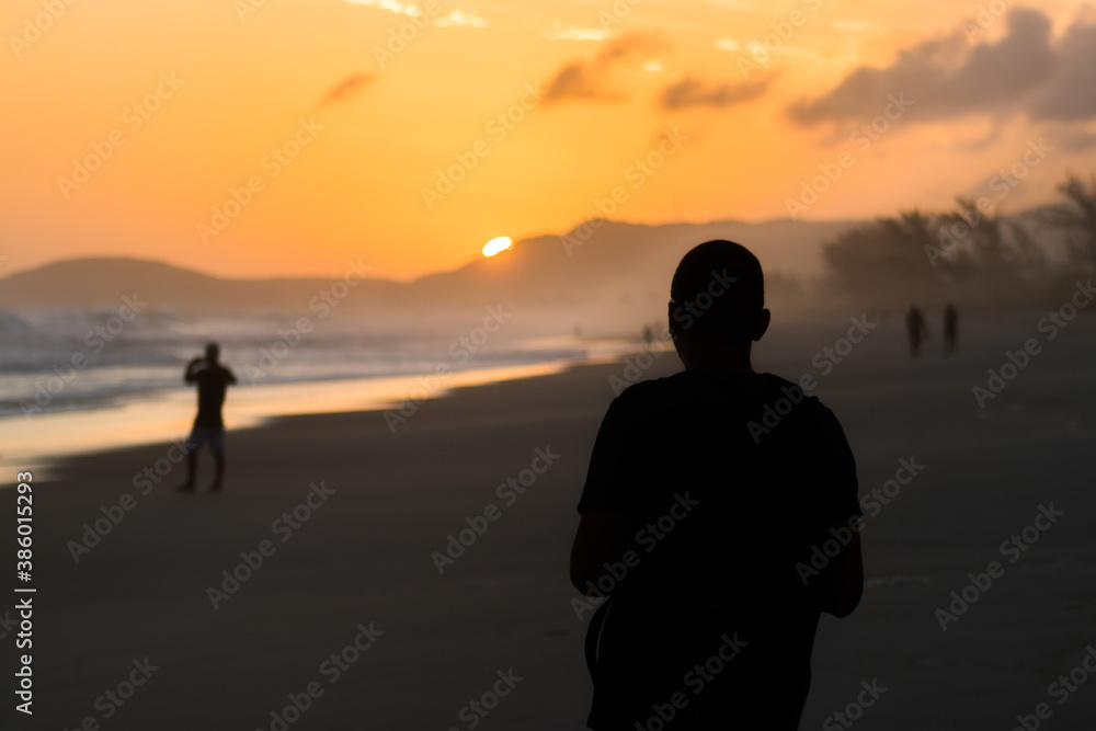 couple walking on the beach at sunset