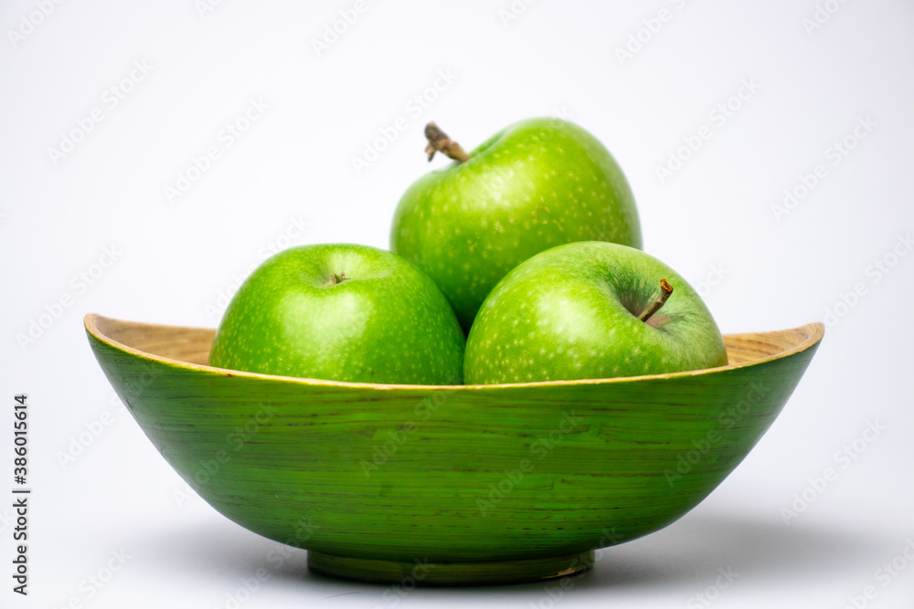Green plate of green apples close up on white background. Green plate of green apples close up on white background.