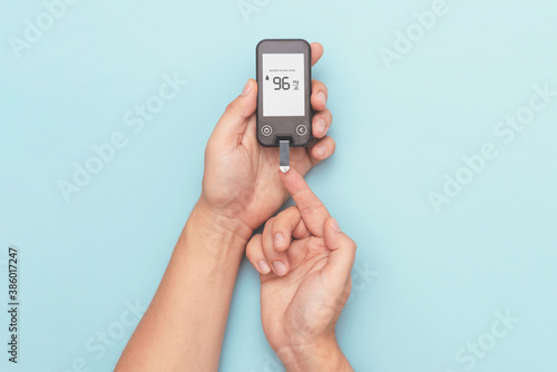 Man using glucometer, checking blood sugar level photo