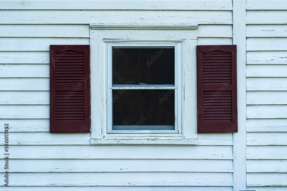 Old window with shutters on a white wooden facade Old window with shutters on a white wooden facade