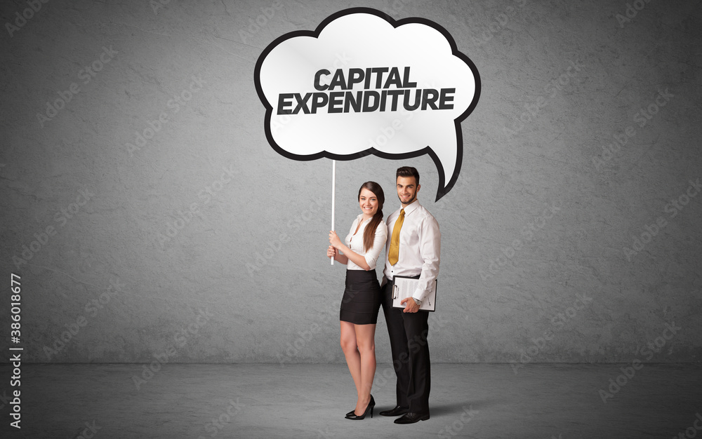 Young business person in casual holding road sign with CAPITAL EXPENDITURE inscription, new business idea concept Young business person in casual holding road sign with CAPITAL EXPENDITURE inscription, new business idea concept