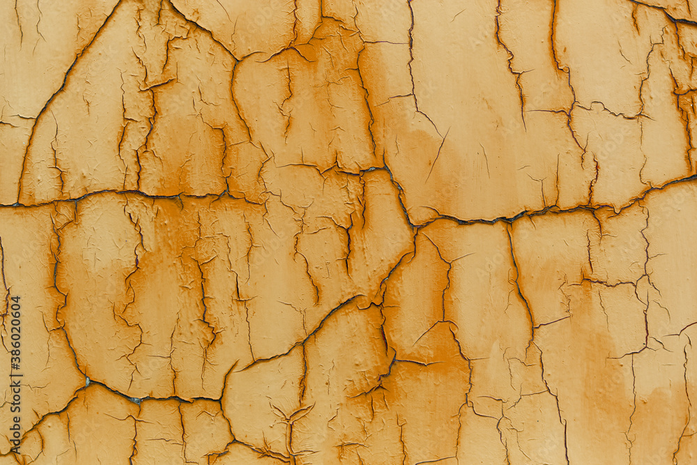 Fototapeta premium Natural abstract background of textured cracked wall of orange color.