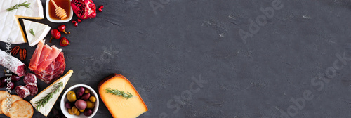 Panel kuchenny z motywem Variety of cheese and meat appetizers. Top view corner border on a dark slate banner background with copy space.
