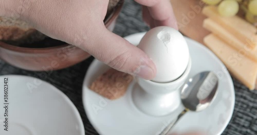 Male hands is shelling chicken eggs. Peels boiled eggs from the shell