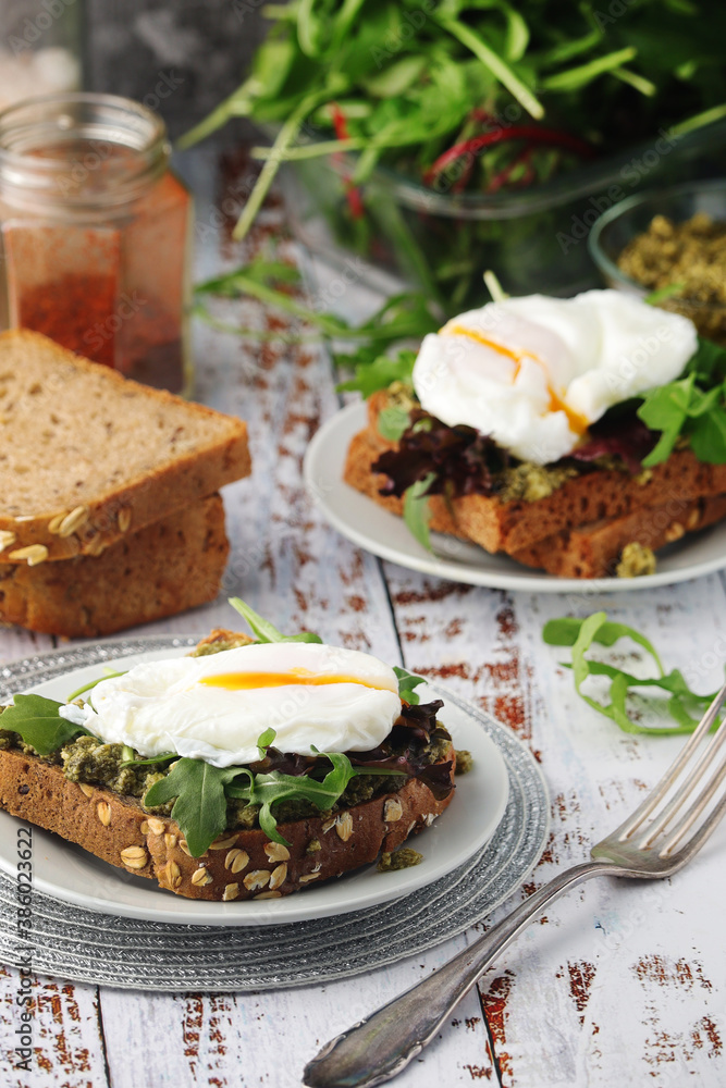 Homemade sandwiches with pesto, green salad and poached eggs