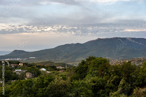 panoramic view of the mountains and the valley against the backdrop of green pine trees and autumn sky © константин константи