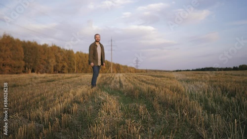 A young man walks in a field with his dog Kurzhaar and plays a flying saucer photo