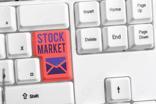 Handwriting text Stock Market. Conceptual photo Particular market where stocks and bonds are traded or exhange Different colored keyboard key with accessories arranged on empty copy space photo