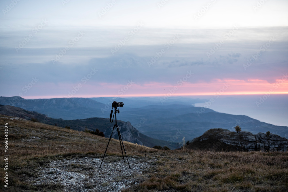 camera on a tripod at sunrise in the mountains