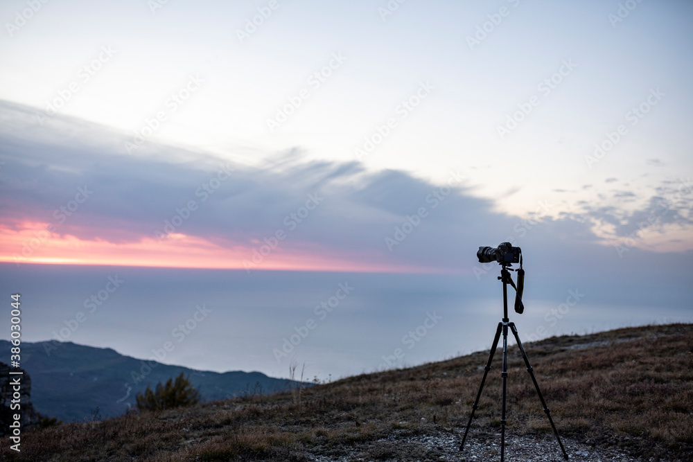 camera on a tripod at sunrise in the mountains