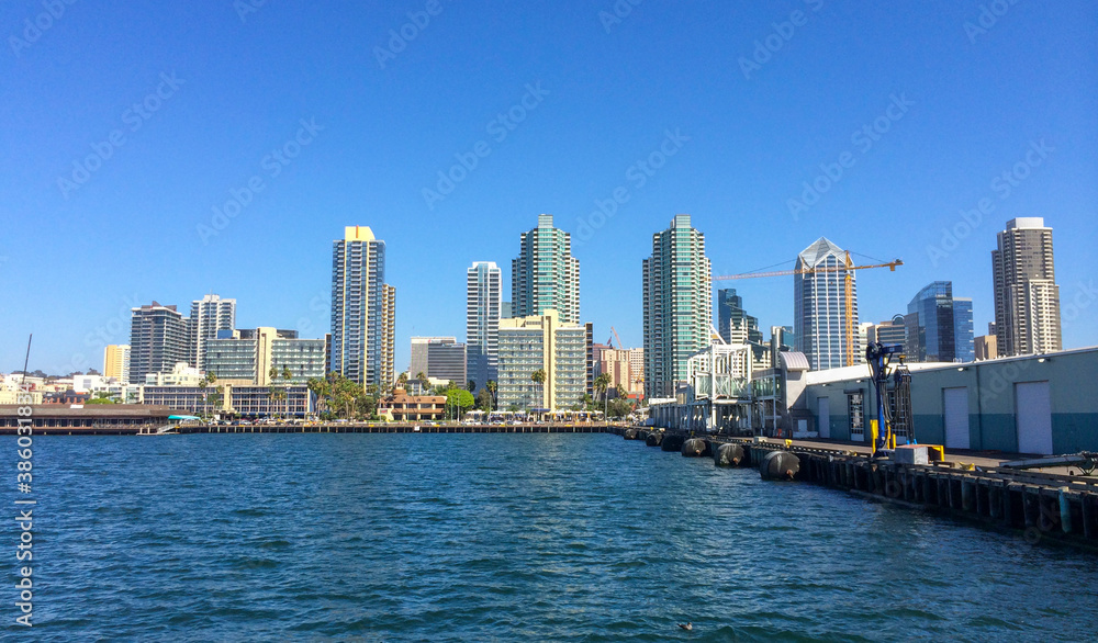 San Diego city buildings, showing the skyscrapers of downtown rising above harbour viewed from sea. Clear sky without clouds and tall buildings.