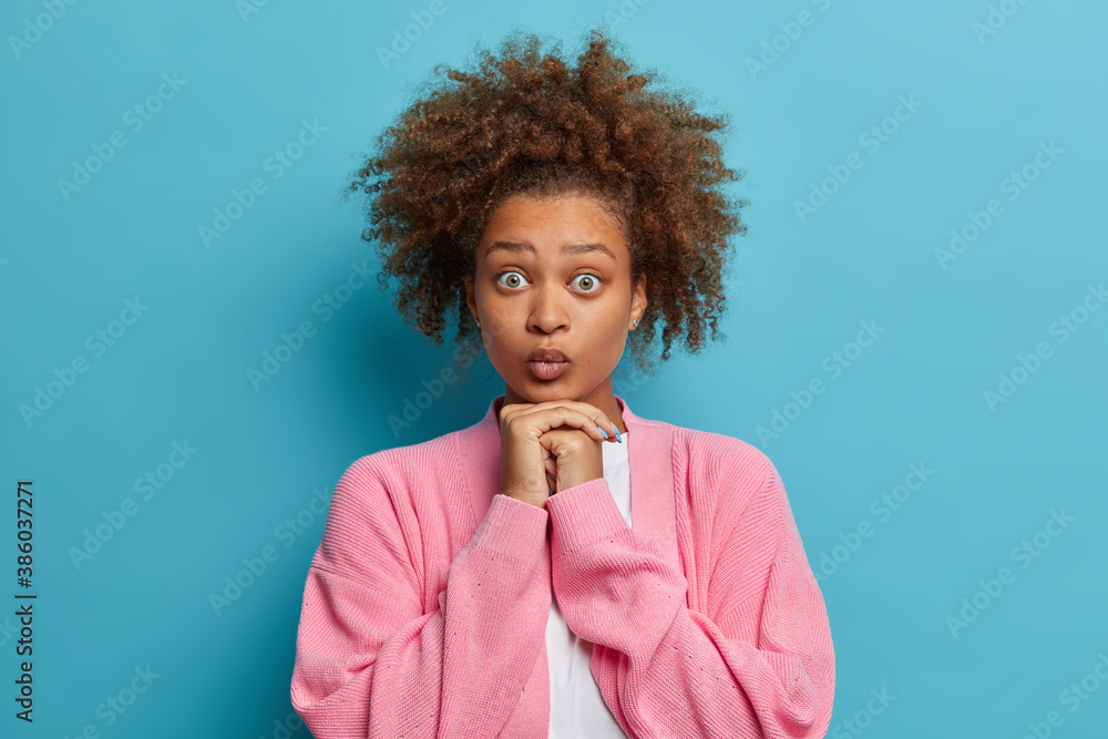 Φωτογραφία Beautiful surprised Afro American teenage girl has bushy curly dark hair keeps h