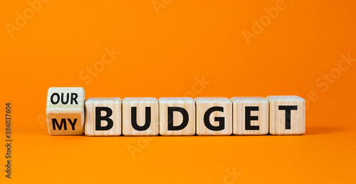 Turned a cube and changed the words 'our budget' to 'my budget' or vice versa. Beautiful orange background. Business concept. Copy space.