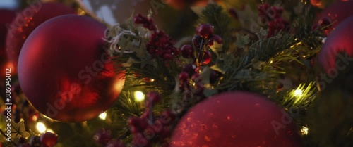 Christmas tree decorated with traditional red toys on the streets of the city. Low angle, close up, slow motion, shallow depth of field. 