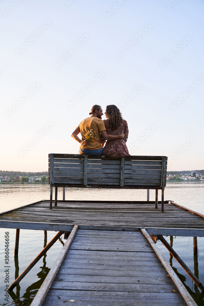 Couple in love sitting on pier