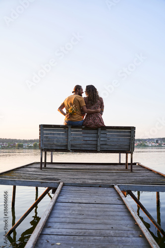 Couple in love sitting on pier © Yakobchuk Olena