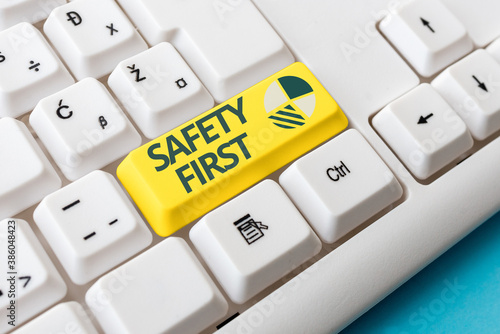 Conceptual hand writing showing Safety First. Concept meaning Avoid any unnecessary risk Live Safely Be Careful Pay attention Colored PC keyboard key With Accessories on Empty background photo