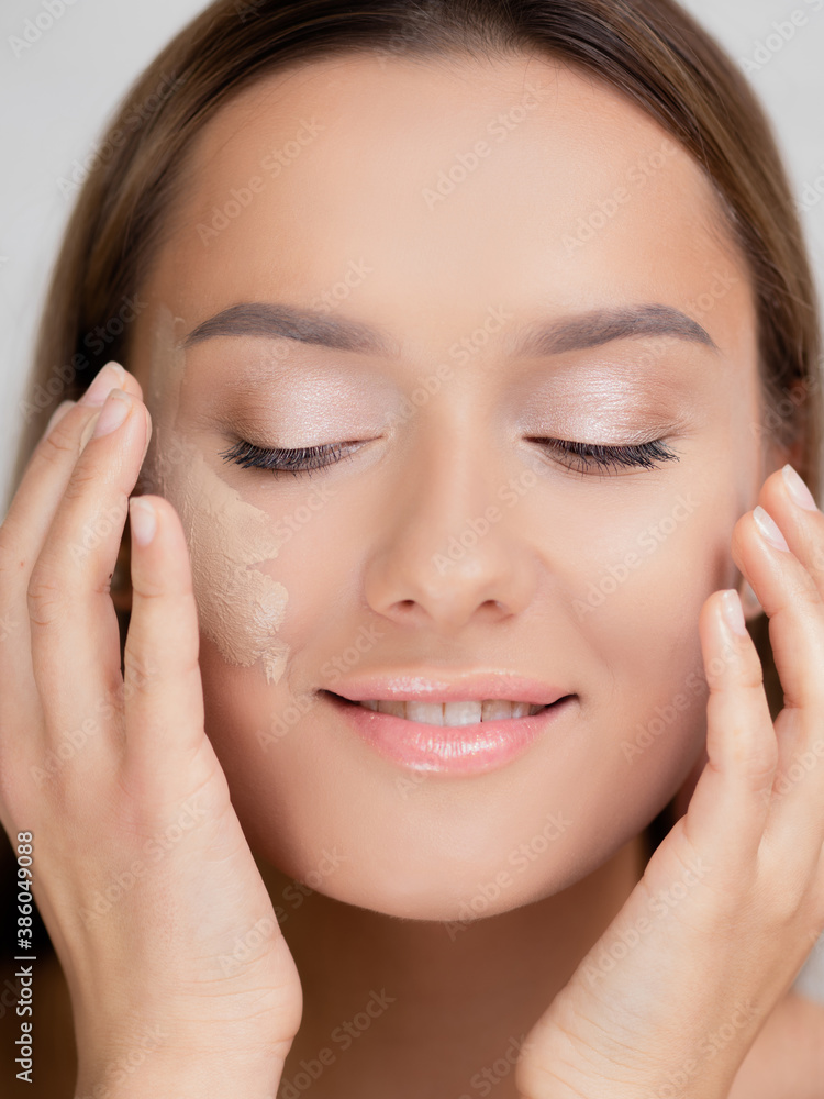 Foundation on the cheek, portrait of a young beautiful woman with beautiful clear skin. Foundation on the cheek, portrait of a young beautiful woman with beautiful clear skin.