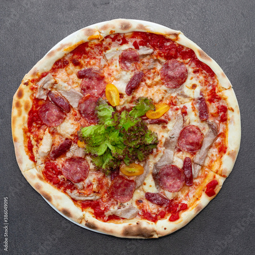Delicious pizza with cheese, salami and basil on table. Top view tasty italian pizza with cheese and sausage