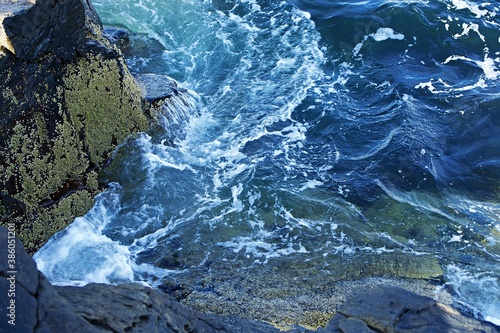 Background of ocean closeup in New England with waves crashing on the rocks
