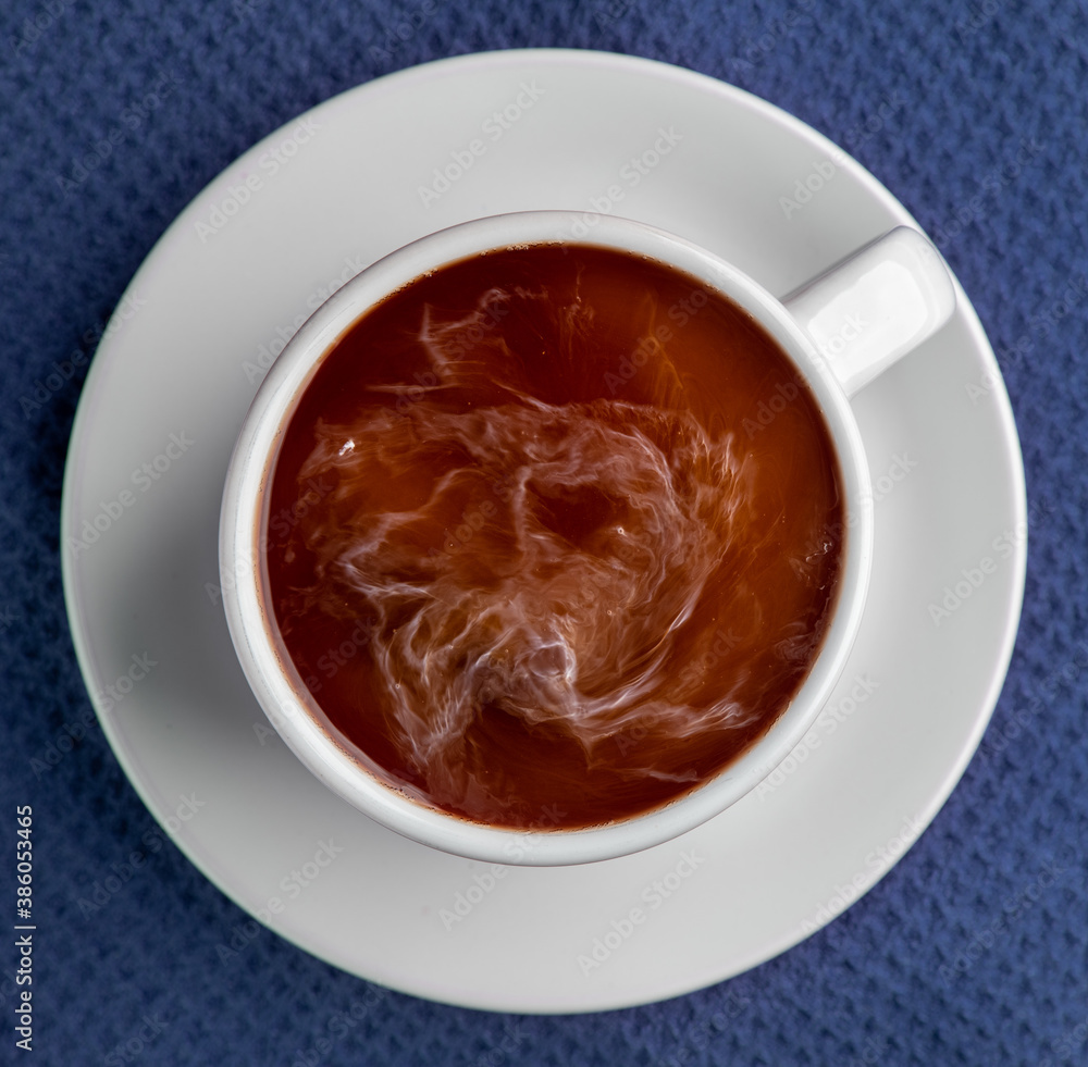 Coffee steaming in a cup with saucer isolated on a blue background looking straight down flat lay Coffee steaming in a cup with saucer isolated on a blue background looking straight down flat lay