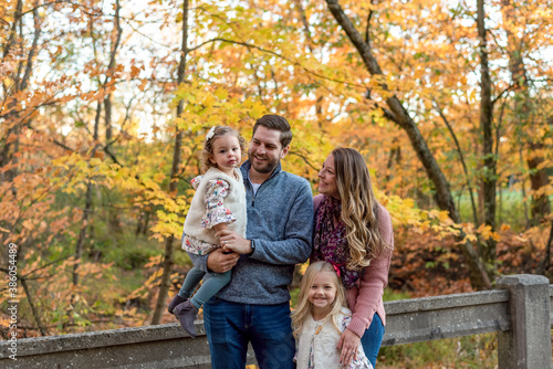 Happy young couple with two little girls in autumn