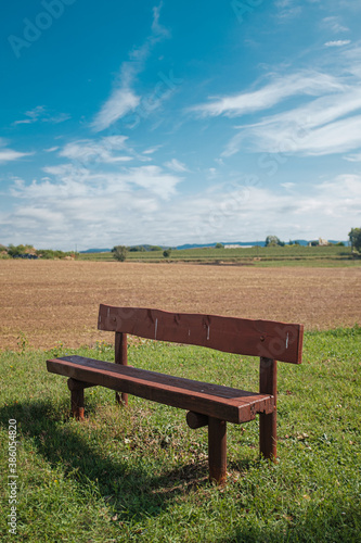 Wooden fence on a green field meadow rural landscape under a blue sunny sky