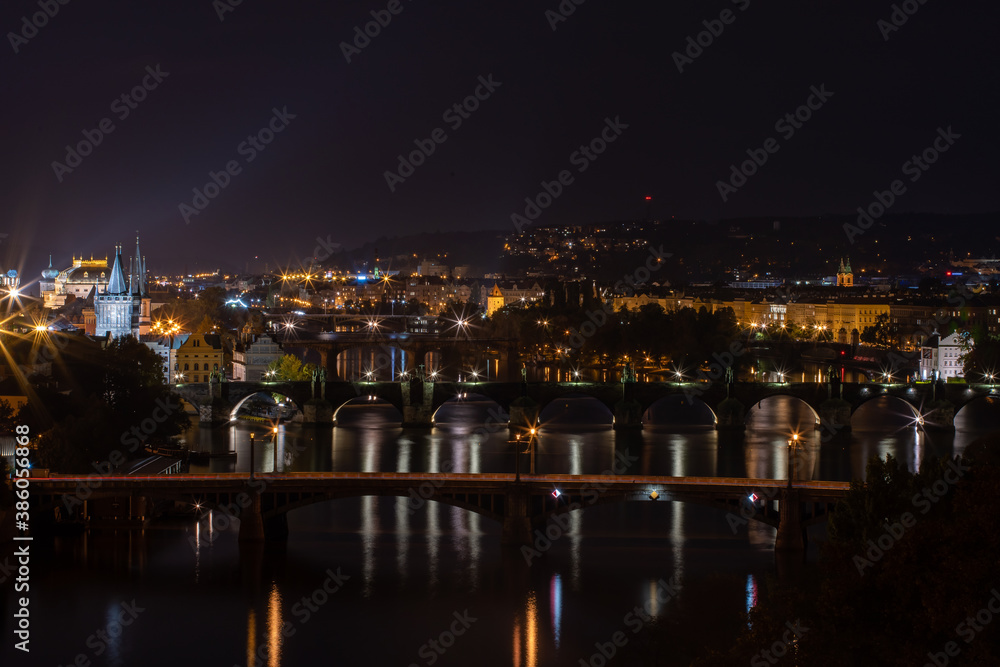 panoramic view of the illuminated city of Prague and the Vltava river and the bridges on it and the light from the street lights in the city center at night
