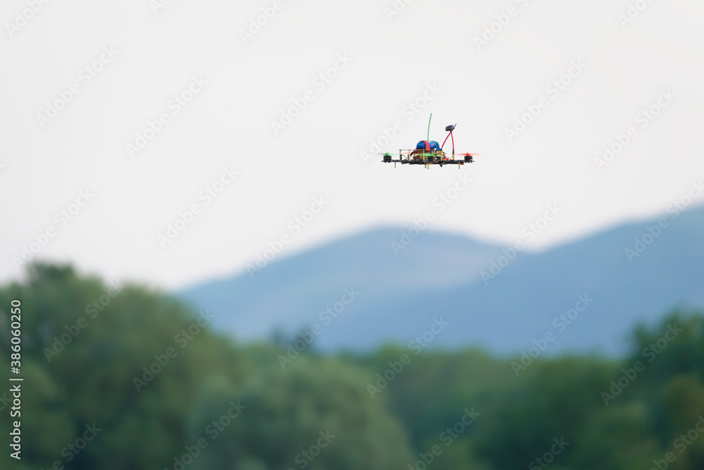 Fototapeta premium Small drone, remote control FPV racing quad copter, flying low.