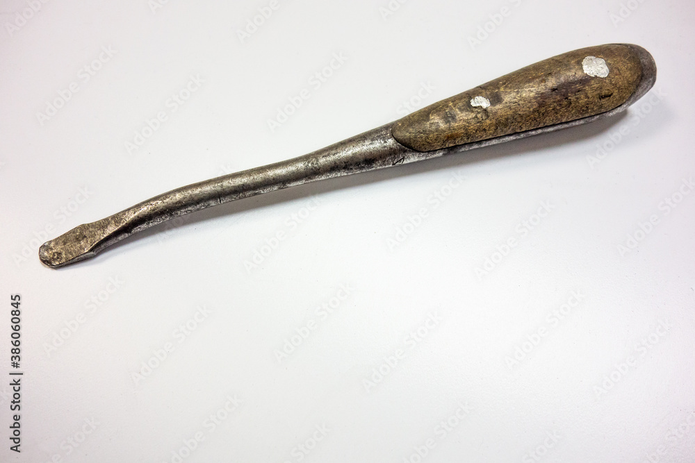 An old curved screwdriver with a wooden handle on white isolate An old curved screwdriver with a wooden handle on white isolate