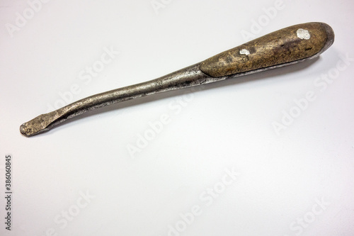An old curved screwdriver with a wooden handle on white isolate