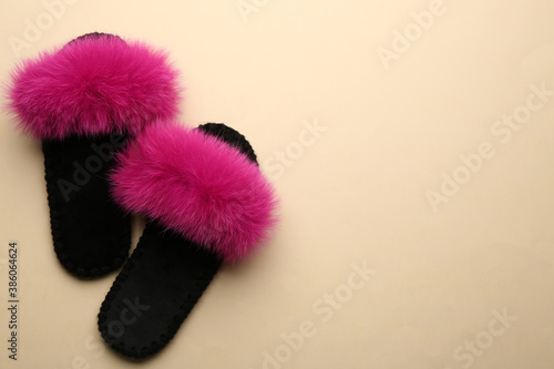 Pair of soft slippers on beige background, flat lay. Space for text