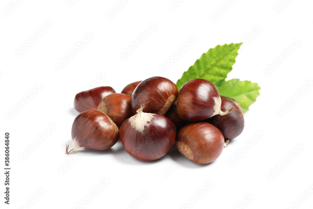 Obraz premium Fresh sweet edible chestnuts with green leaves on white background
