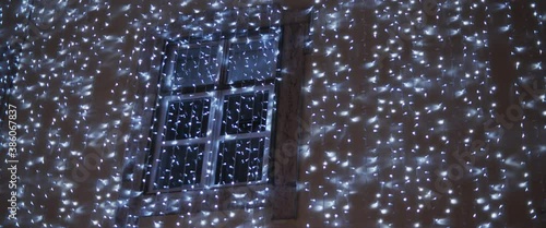 Building facade decorated with blue garland lights for the Christmas holiday season. Slow motion. 