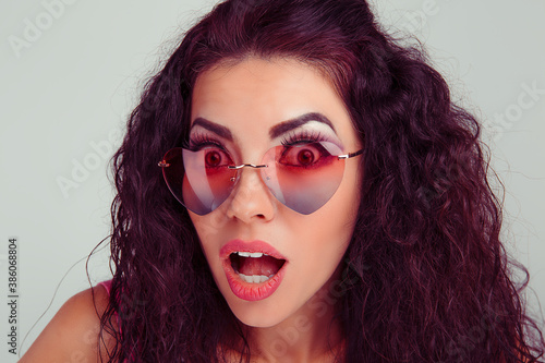 Woman with heart shaped glasses happy surprised