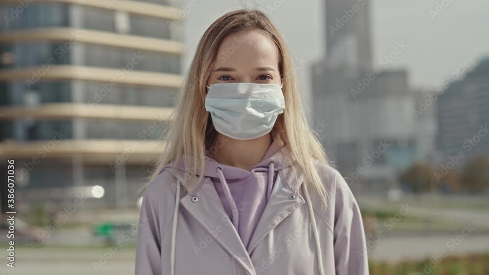 Pandemic Covid-19. Portrait nice brunette caucasian girl taking on medical mask and smiling. Health care, face protection. Quarantine. Pandemic Covid-19. Portrait nice brunette caucasian girl taking on medical mask and smiling. Health care, face protection. Quarantine.