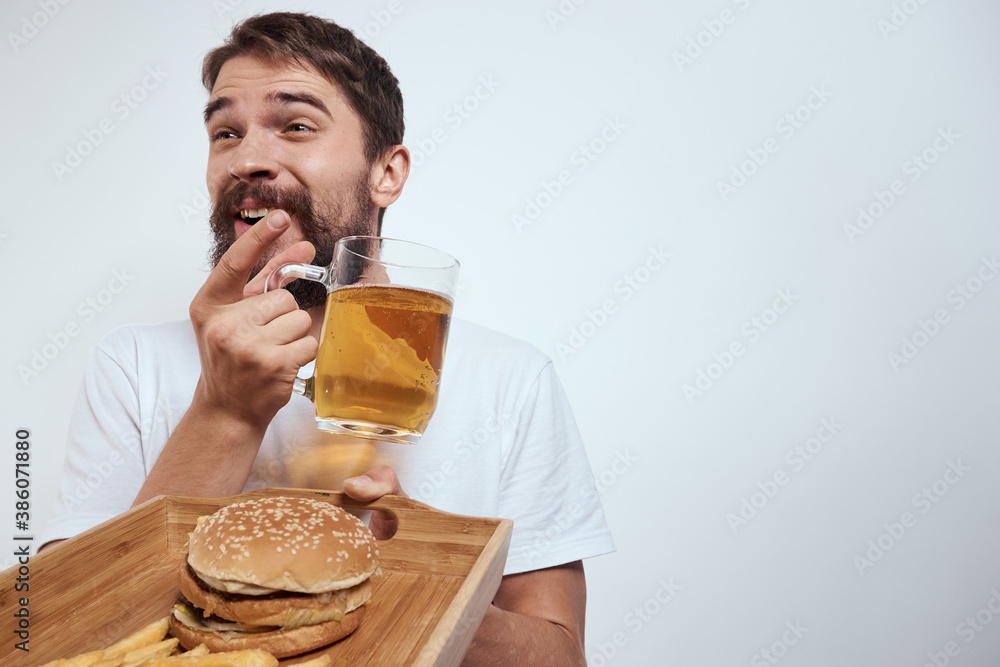 man with wooden tray beer mug french fries and hamburger fast food calories model white t-shirt man with wooden tray beer mug french fries and hamburger fast food calories model white t-shirt
