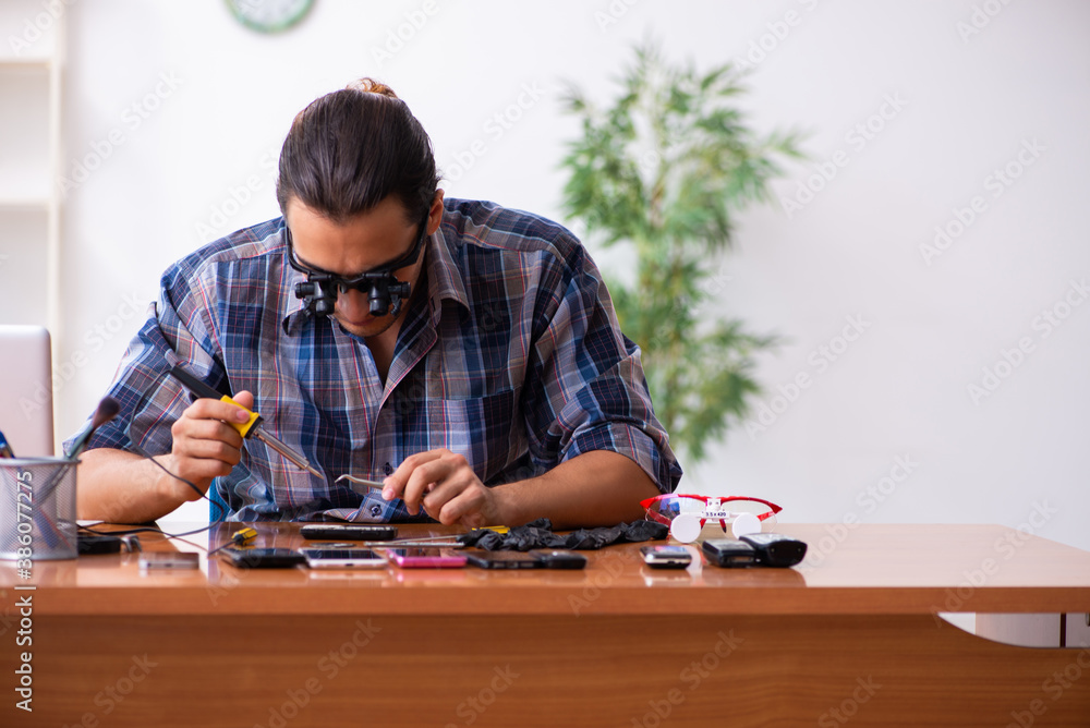 Young male technician repairing mobile phone Young male technician repairing mobile phone