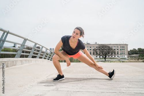 Athletic woman stretching legs before exercise.