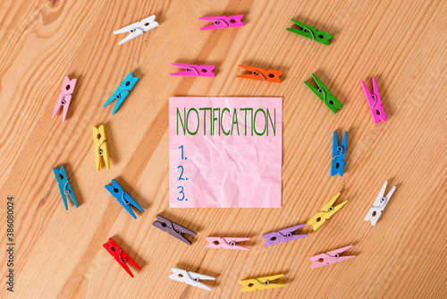 Conceptual hand writing showing Notification. Concept meaning act or instance of notifying, written matter that gives notice Colored crumpled papers wooden floor background clothespin photo