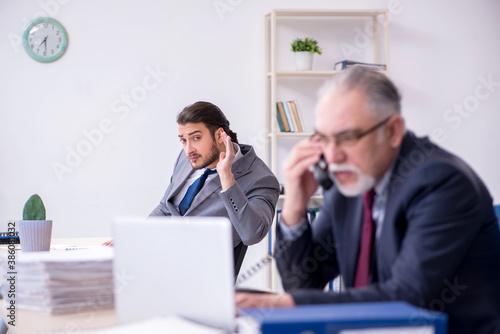 Old boss and his young assistant working in the office