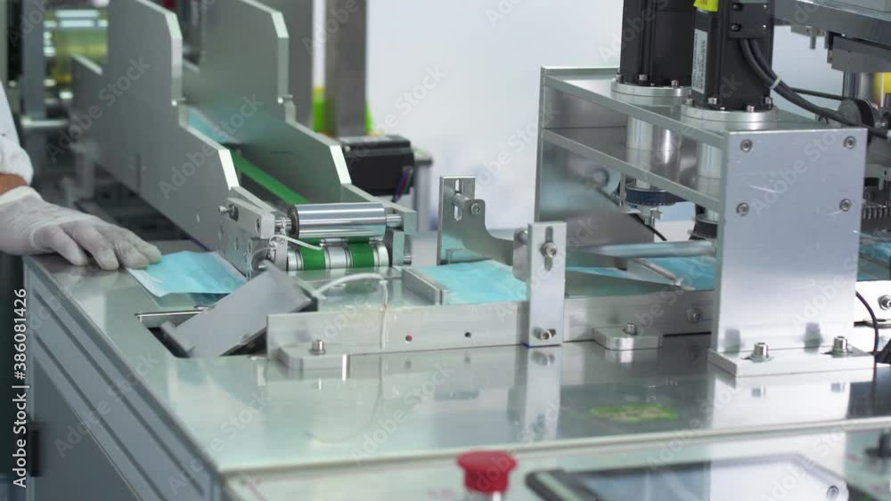 Machines are working for producing masks in a sterile factory. Production of medical masks. process of manufacturing a mask Machines are working for producing masks in a sterile factory. Production of medical masks. process of manufacturing a mask