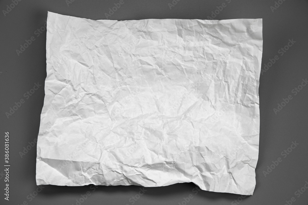 white and gray crumpled paper on gray background. crush paper so that it becomes creased and wrinkled. white and gray crumpled paper on gray background. crush paper so that it becomes creased and wrinkled.
