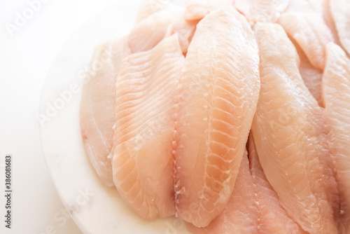 Close up of fresh raw tilapia fish fillet on white background