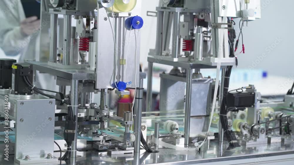 Machines are working for producing masks in a sterile factory. Production of medical masks. process of manufacturing a mask Machines are working for producing masks in a sterile factory. Production of medical masks. process of manufacturing a mask