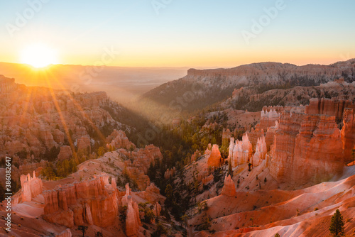 Bryce Canyon National Park sunrise. Sandstone spires and pine trees in morning sunshine