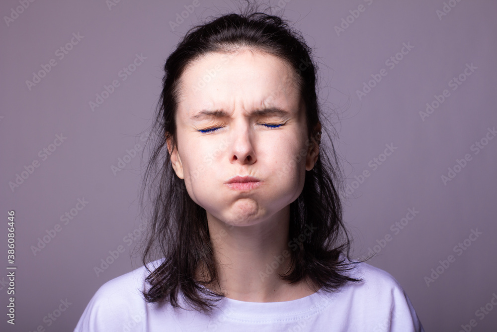 emotional woman in white t-shirt on gray studio background emotional woman in white t-shirt on gray studio background